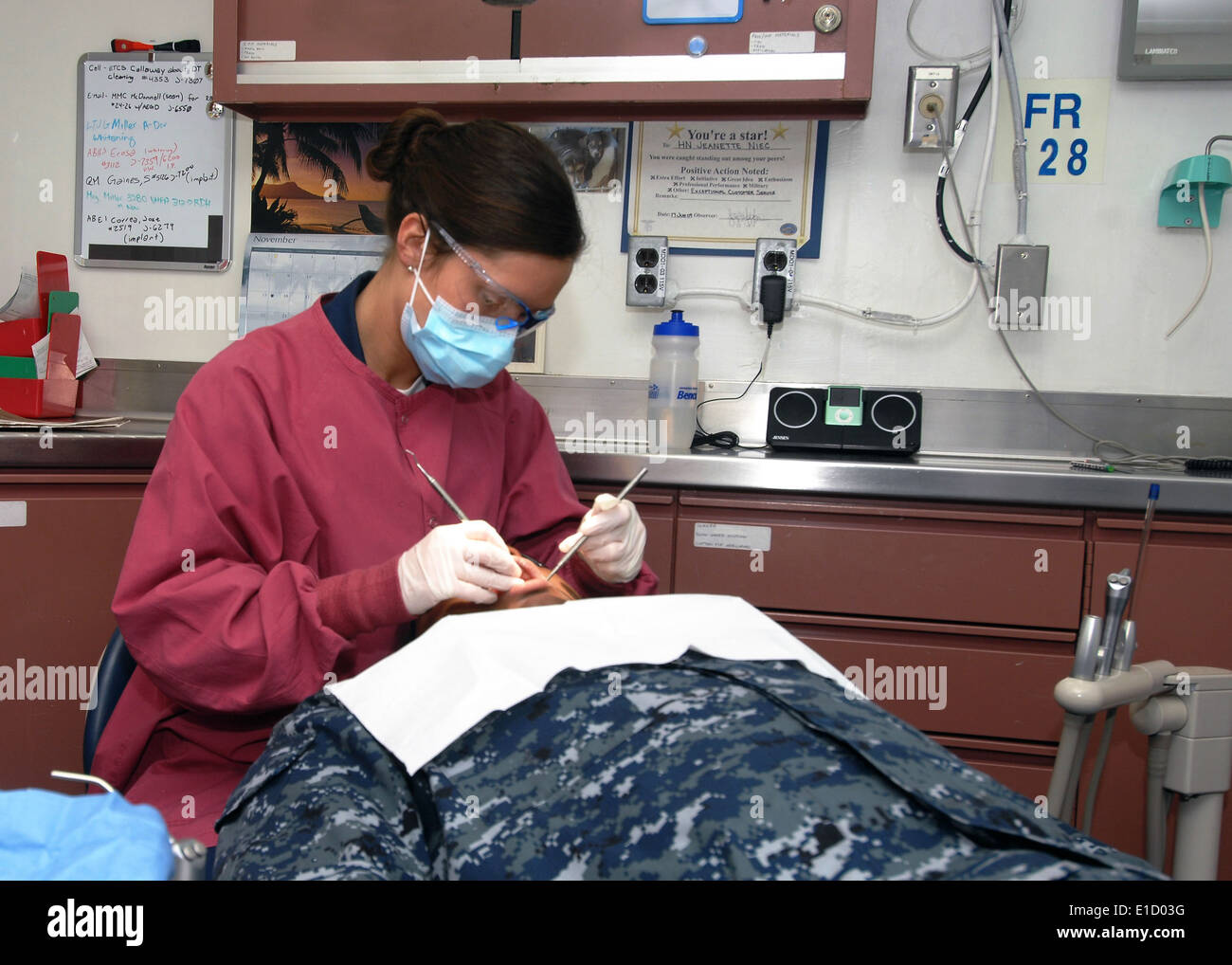 Stati Uniti Navy Corpsman ospedale di terza classe Emily Brown esegue una routine di pulizia dentale su un marinaio a bordo della portaerei US Foto Stock