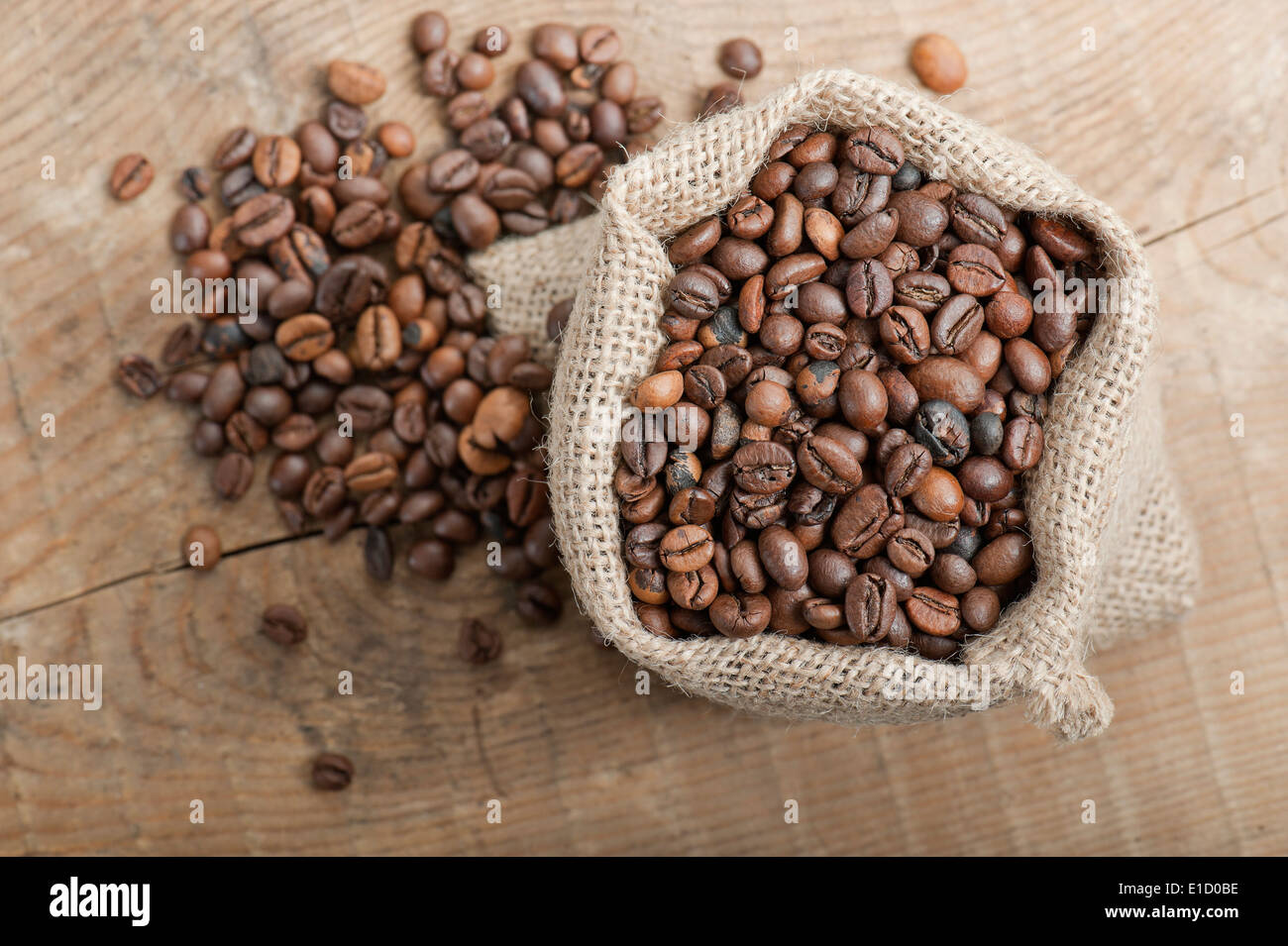 I chicchi di caffè in juta Sacco sul tavolo di legno Foto Stock