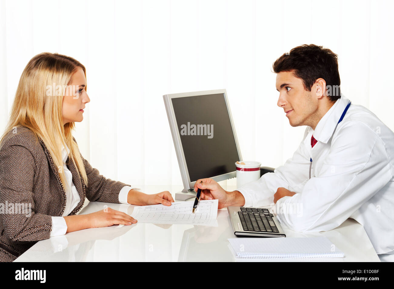 I medici intervista. Il paziente e il medico di parlare a un ambulatorio medico Foto Stock