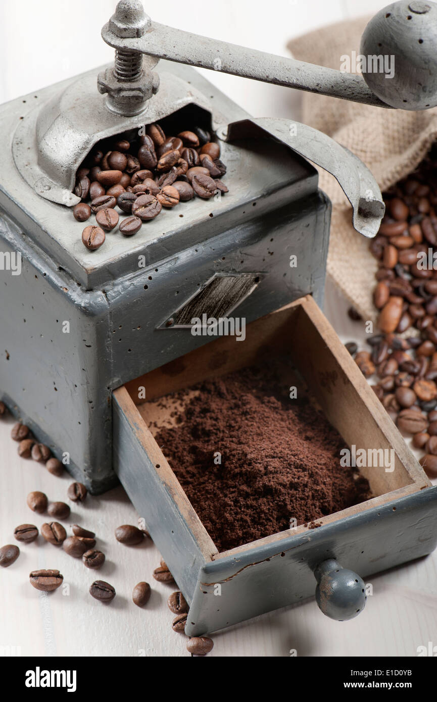 Vecchio macinino da caffè con tela e i chicchi di caffè sul tavolo in legno Foto Stock