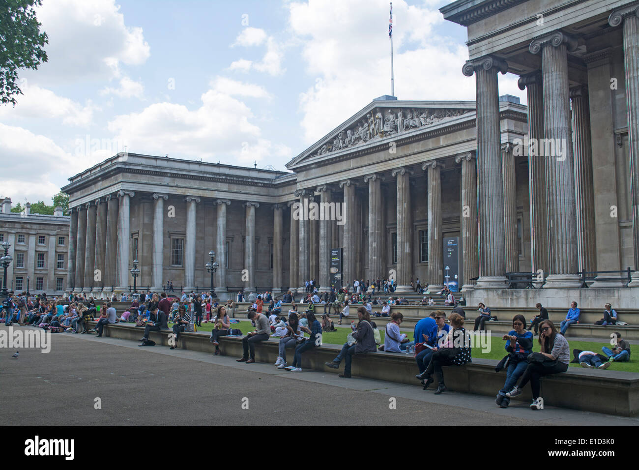 La gente seduta fuori l'ingresso al British Museum di Londra, Inghilterra Foto Stock