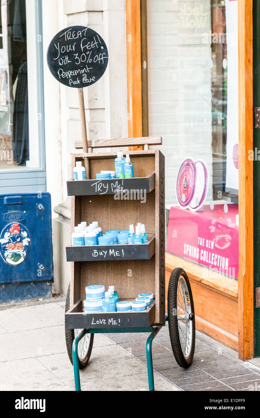 Carrello di legno, al di fuori di una salute & bellezza finestra, riempita con la menta piperita piede prodotti sanitari, pubblicità di sconto Foto Stock