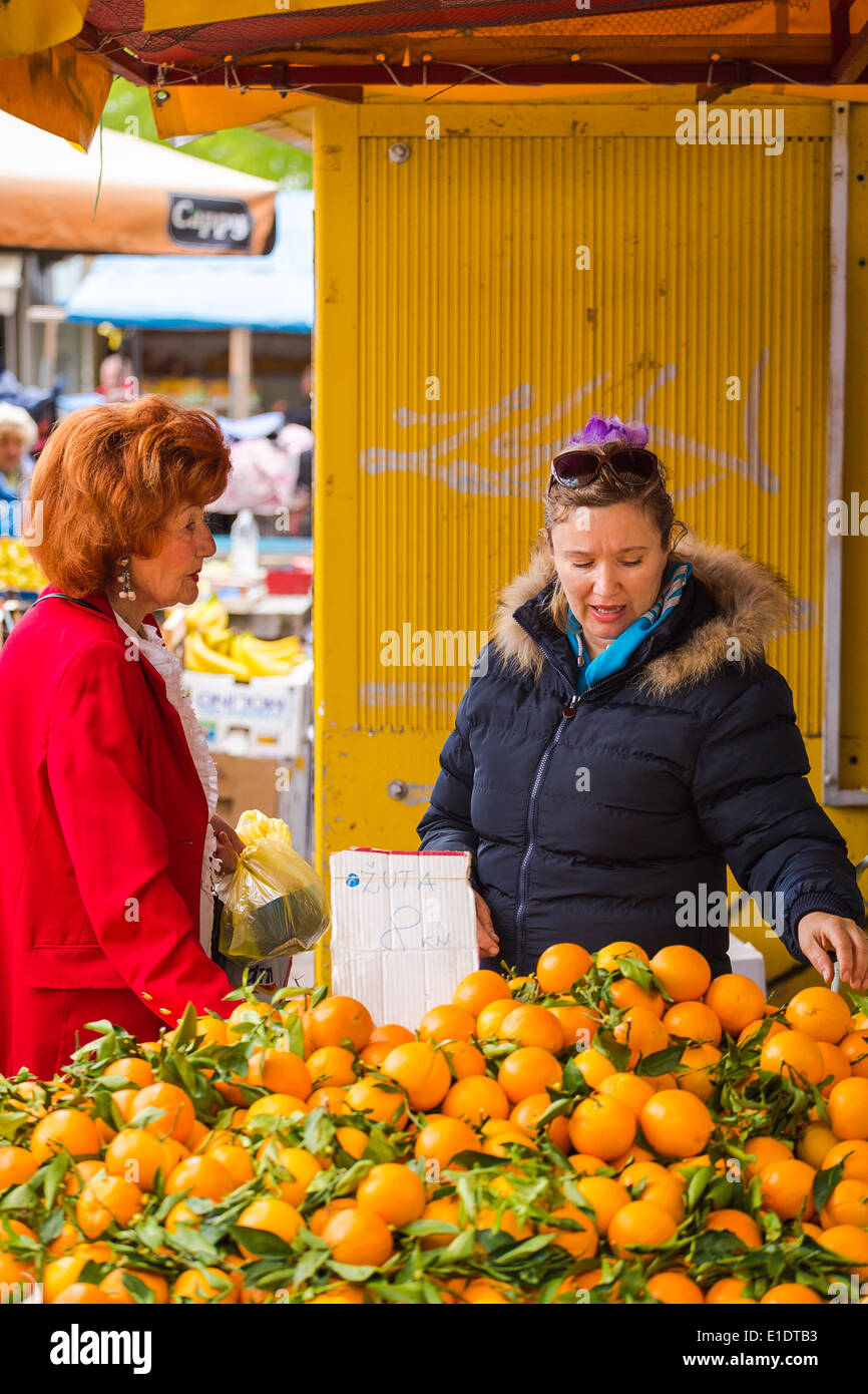 Una donna vende frutta fresca dal suo stallo a il mercato giornaliero in Split Croazia Foto Stock