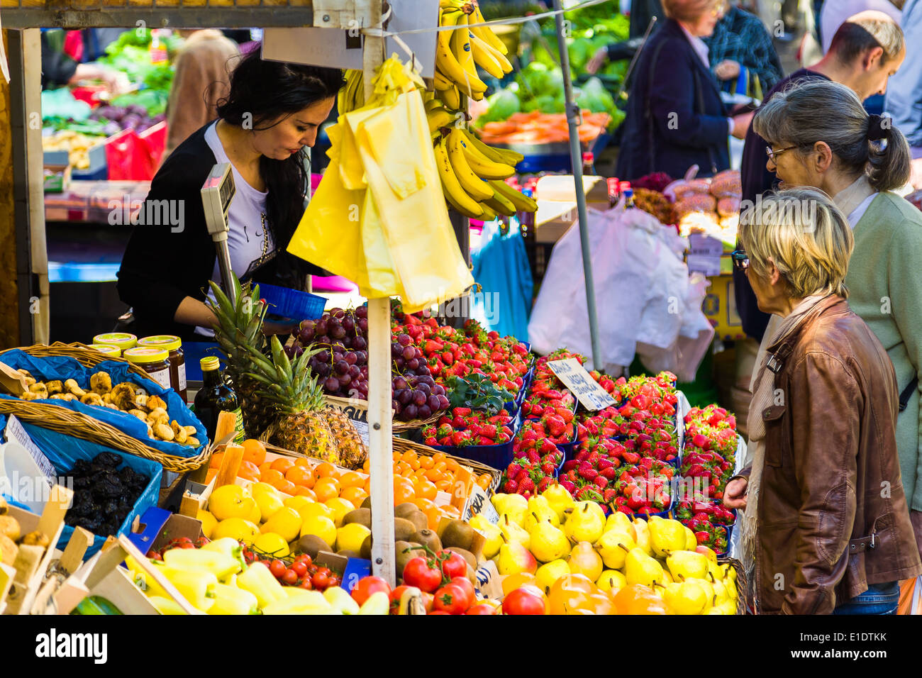 Una donna che vende le verdure fresche dal suo stallo a il mercato giornaliero in Split Croazia Foto Stock