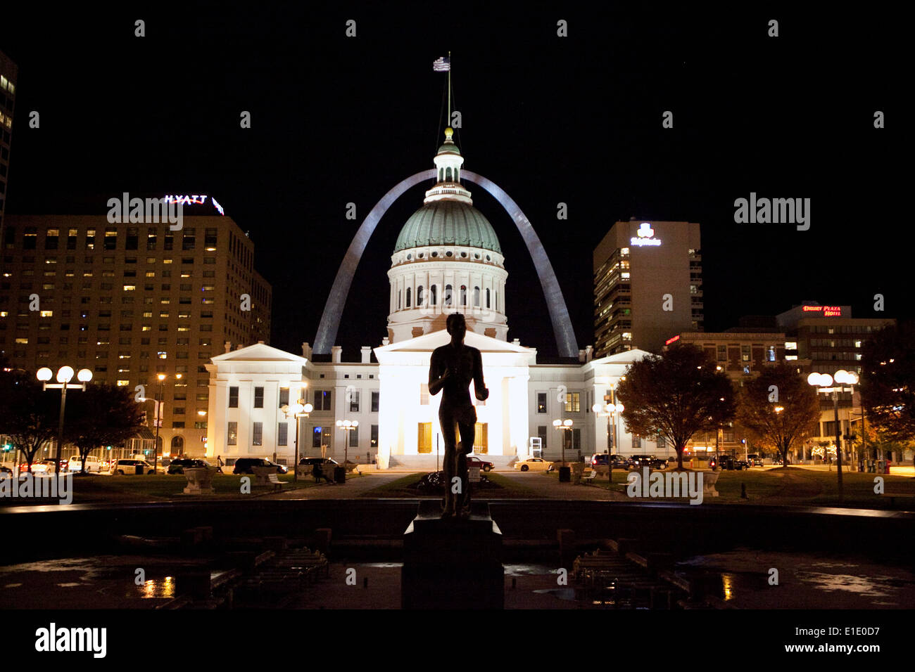 Il Gateway Arch è visto dietro il tribunale Vecchio e Statua di Runner di notte a St Louis, Missouri Foto Stock