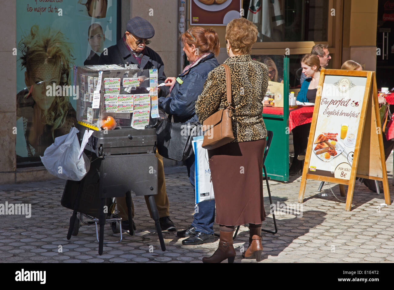 Signora acquisto biglietto della lotteria da venditore ambulante, Malaga, Spagna Foto Stock