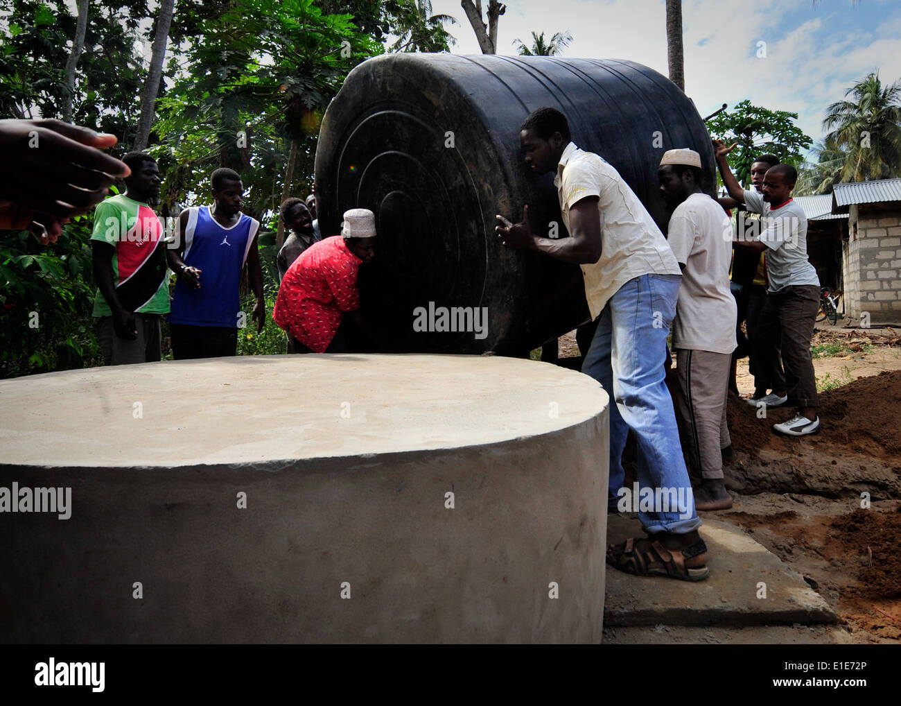 I residenti in Fundo Island, un piccolo isolotto che è parte della isola di Pemba, Tanzania, portano a 5.000 litri di cisterna di acqua ad una concreta Foto Stock