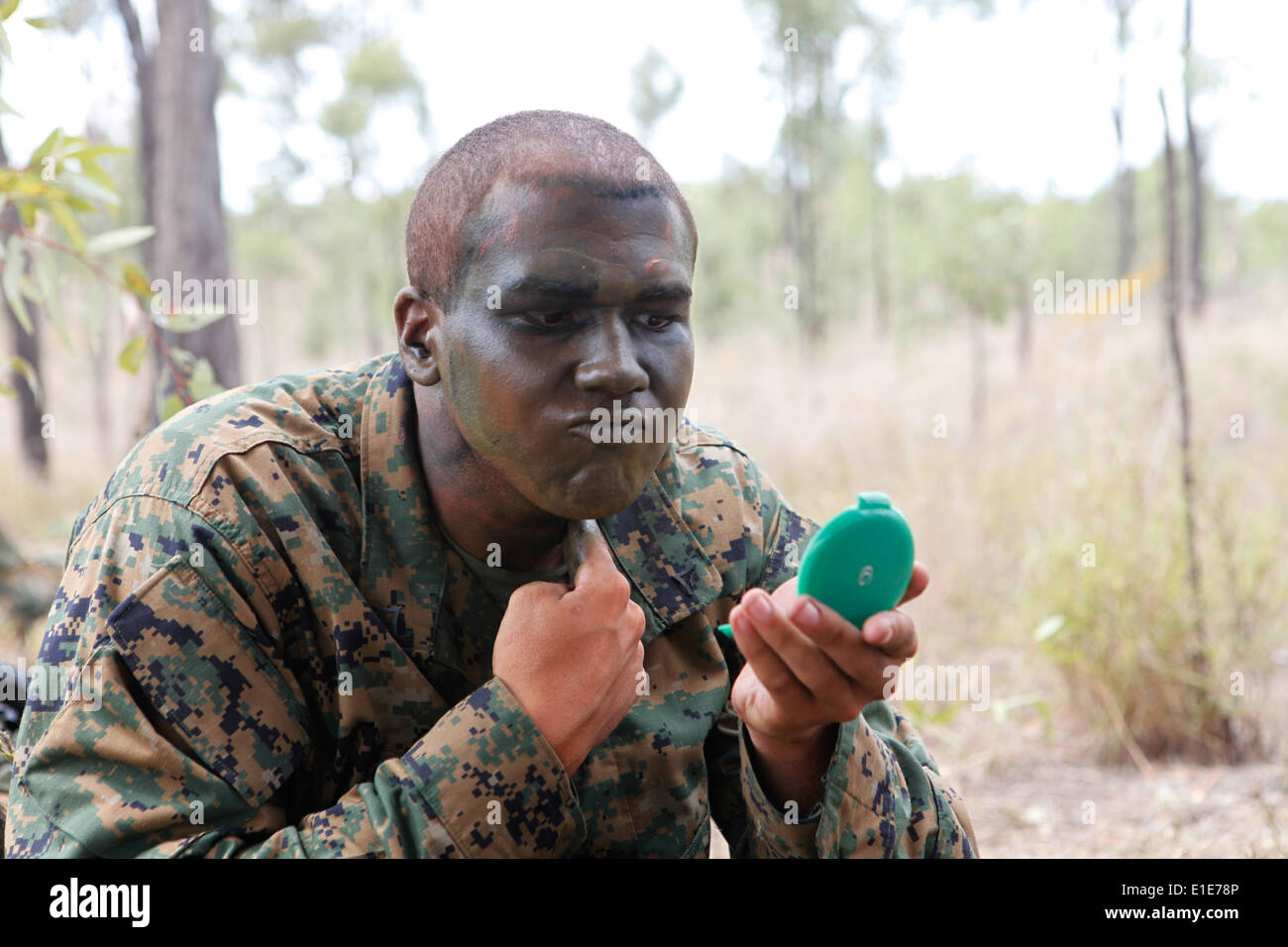 Stati Uniti Marine Corps Lance Cpl. Michael Ellmer, assegnato ad alfa Co., 1° Battaglione, 3° Reggimento Marine, si applica il dolore di mimetizzazione Foto Stock