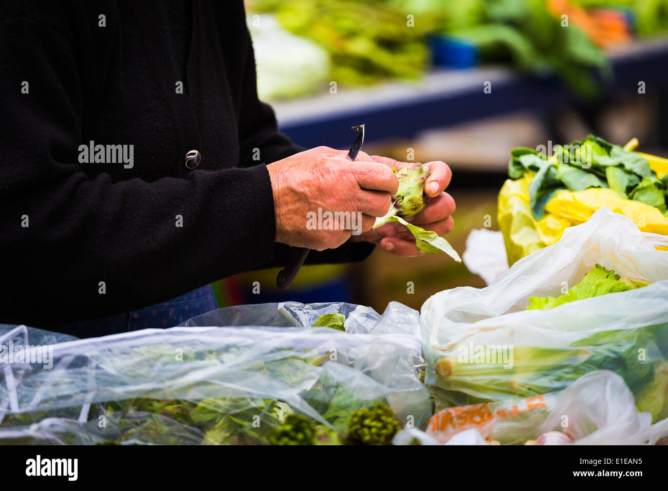 Una donna che prepara le verdure fresche a lei in stallo il mercato giornaliero in Split Croazia Foto Stock