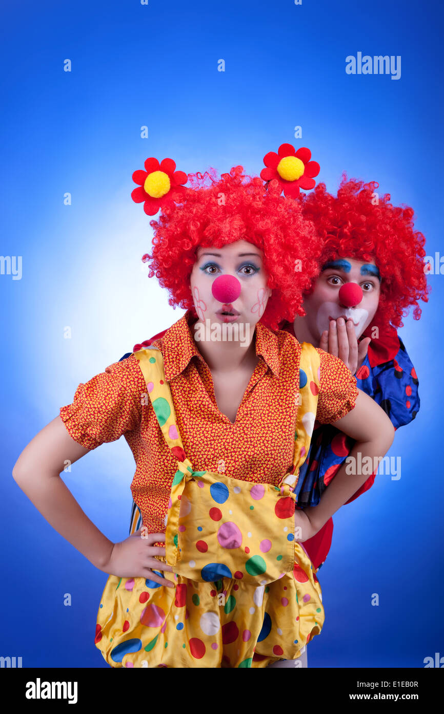 Clown matura in costumi su sfondo blu. Studio di illuminazione professionale. Colori brillanti Foto Stock
