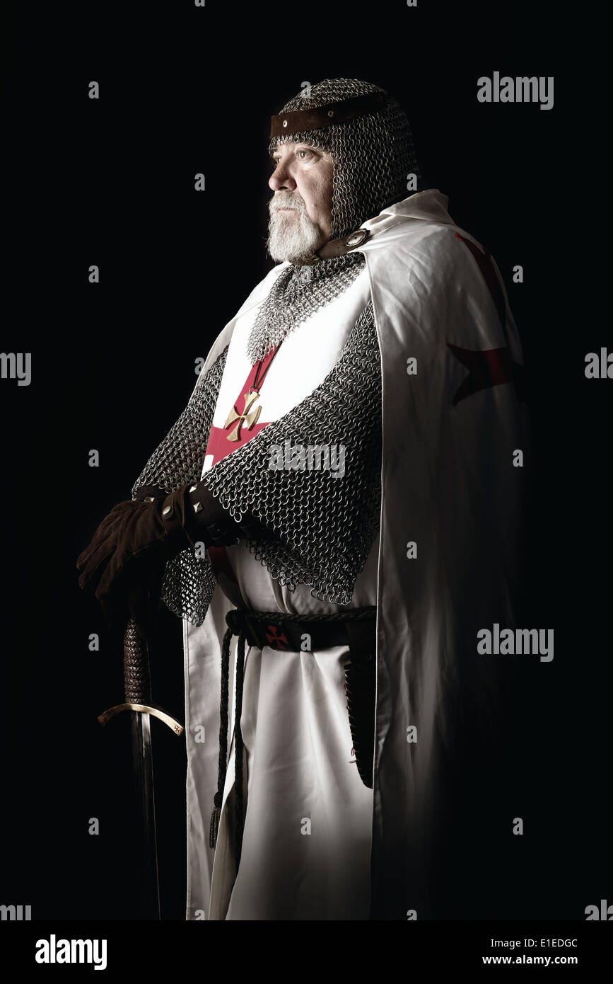 Cavaliere Templare in posa con la spada in uno sfondo scuro Foto Stock