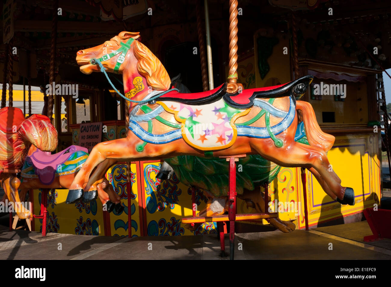 Un vecchio stile cavalli al galoppo fairground ride nel parco di divertimenti a Hunstanton, Norfolk. Foto Stock
