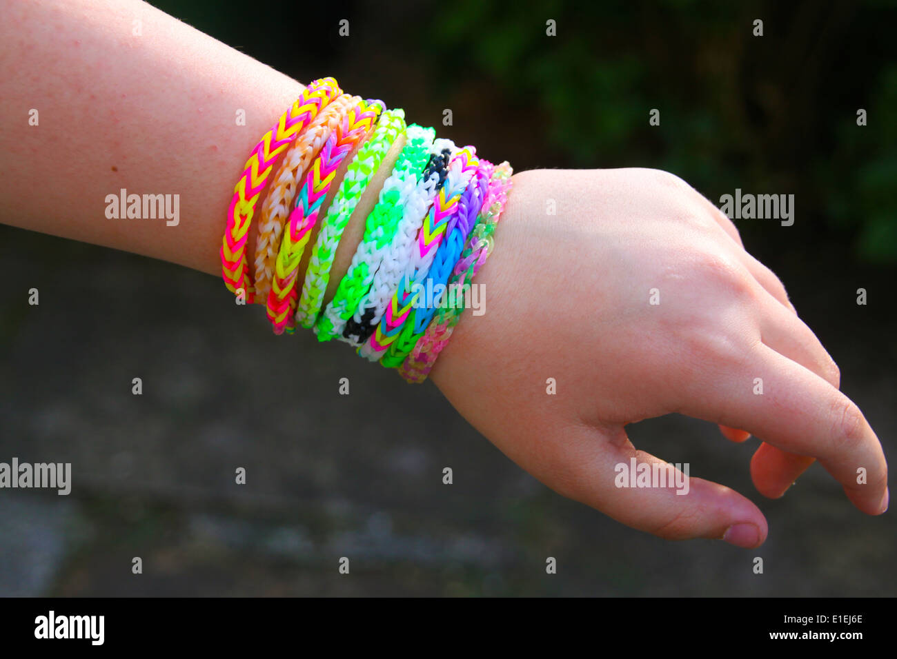 Giovane ragazza mostra il telaio rainbow band bracciali sul suo polso Foto Stock