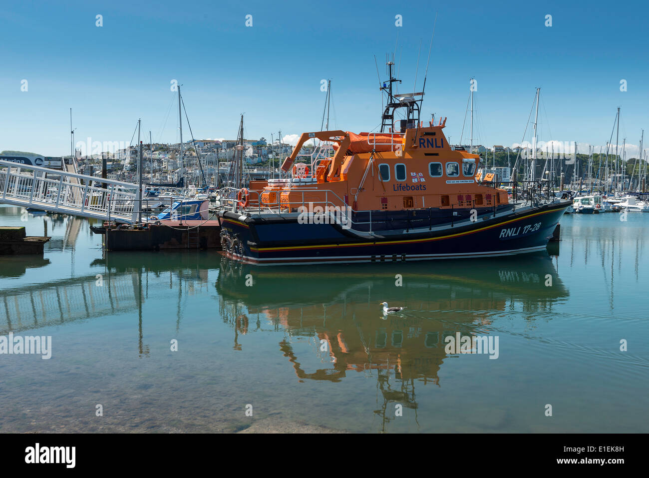 Scialuppa di salvataggio ormeggiata nel porto di Brixham nel Devon, Inghilterra Occidentale UK con barche e yacht ormeggiati in porto in background Foto Stock