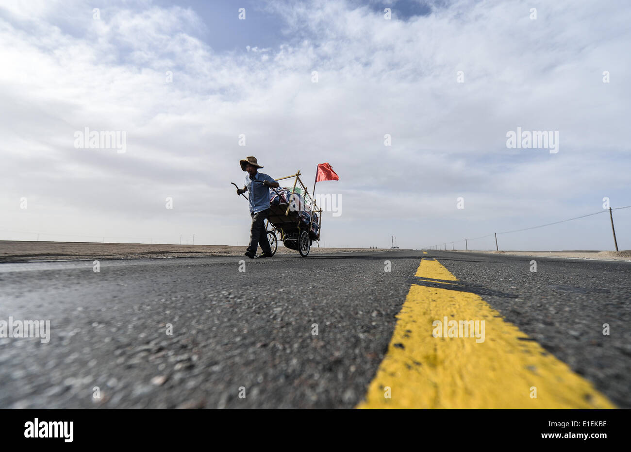 (140602) -- GOLMUD, Giugno 2, 2014 (Xinhua) -- Li Zongtao passeggiate sulla Qinghai-Tibet Highway, a nord-ovest della Cina di Provincia di Qinghai, 30 maggio 2014. Li Zongtao, 47, era una volta un camionista in esecuzione sull'autostrada Sichuan-Tibet. Egli ha iniziato il tour escursioni di viaggio in Cina nel marzo 2009, partendo dal sud-ovest della Cina di Chengdu. Durante il tour, ha fatto una vita da bottiglie di vendita ha colleted lungo la strada. Egli ha camminato con il suo camion in 26 province finora, trekking oltre 20.000 chilometri. (Xinhua/Wu Gang) (mp) Foto Stock