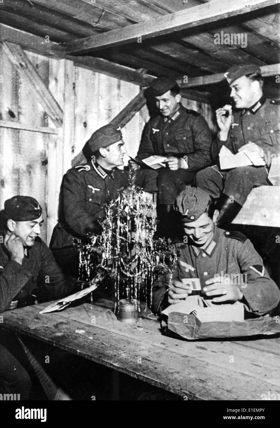 I soldati della Wehrmacht tedesca hanno letto le lettere di Natale in una casa di legno sul fronte orientale, pubblicato il 24 dicembre 1941. Testo di propaganda! Dalle notizie naziste che riportano sul retro della foto: 'Natale in tempo di guerra. L'albero di Natale e la posta di Natale di persone care a casa fanno dimenticare al soldato per un momento che è seduto in una casa di legno crudelmente costruita". (Difetti di qualità dovuti alla copia storica dell'immagine) Fotoarchiv für Zeitgeschichtee - NESSUN SERVIZIO DI CABLAGGIO – Foto Stock