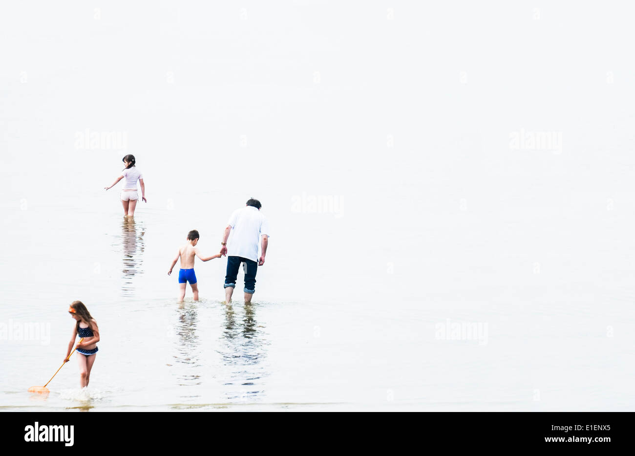 Bambini sguazzare con il loro padre a Southend on Sea. Foto Stock