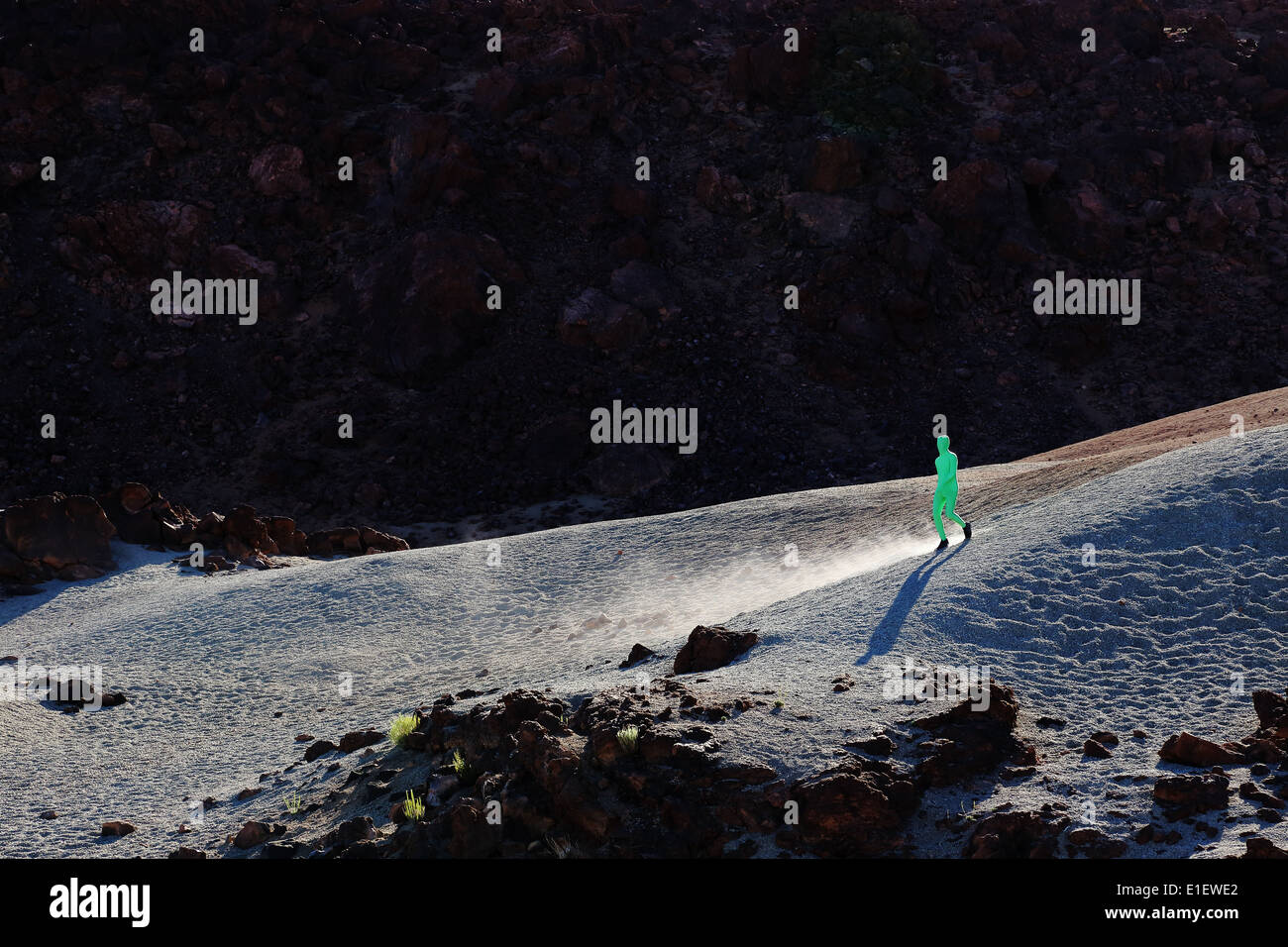 Uomo che indossa verde Abito MARZIANO passeggiando per le dune nel Parco Nazionale del Teide, Tenerife, Isole canarie, Spagna Foto Stock