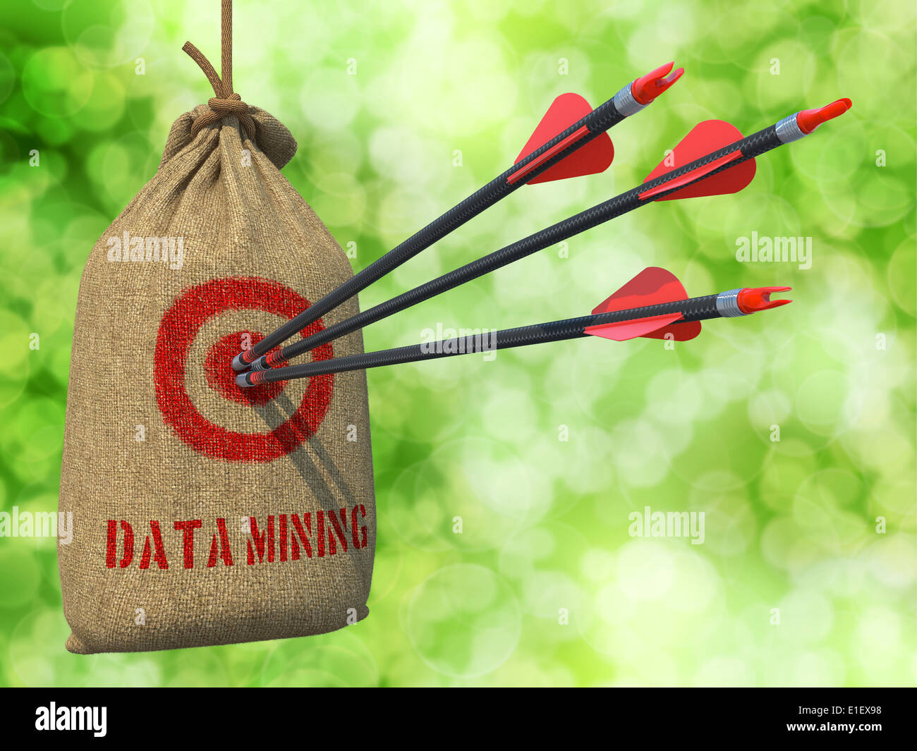 Data Mining - Tre frecce ha colpito in rosso sul bersaglio appeso un sacco sul verde sfondo bokeh di fondo. Foto Stock