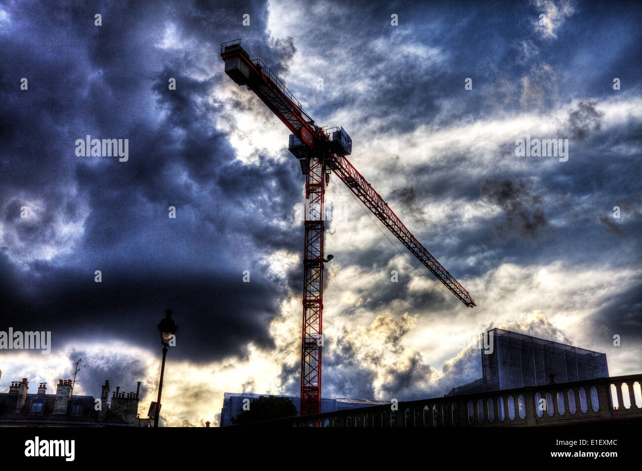 Gru a torre costruzione drammatica nuvole del cielo edificio imponente Foto Stock