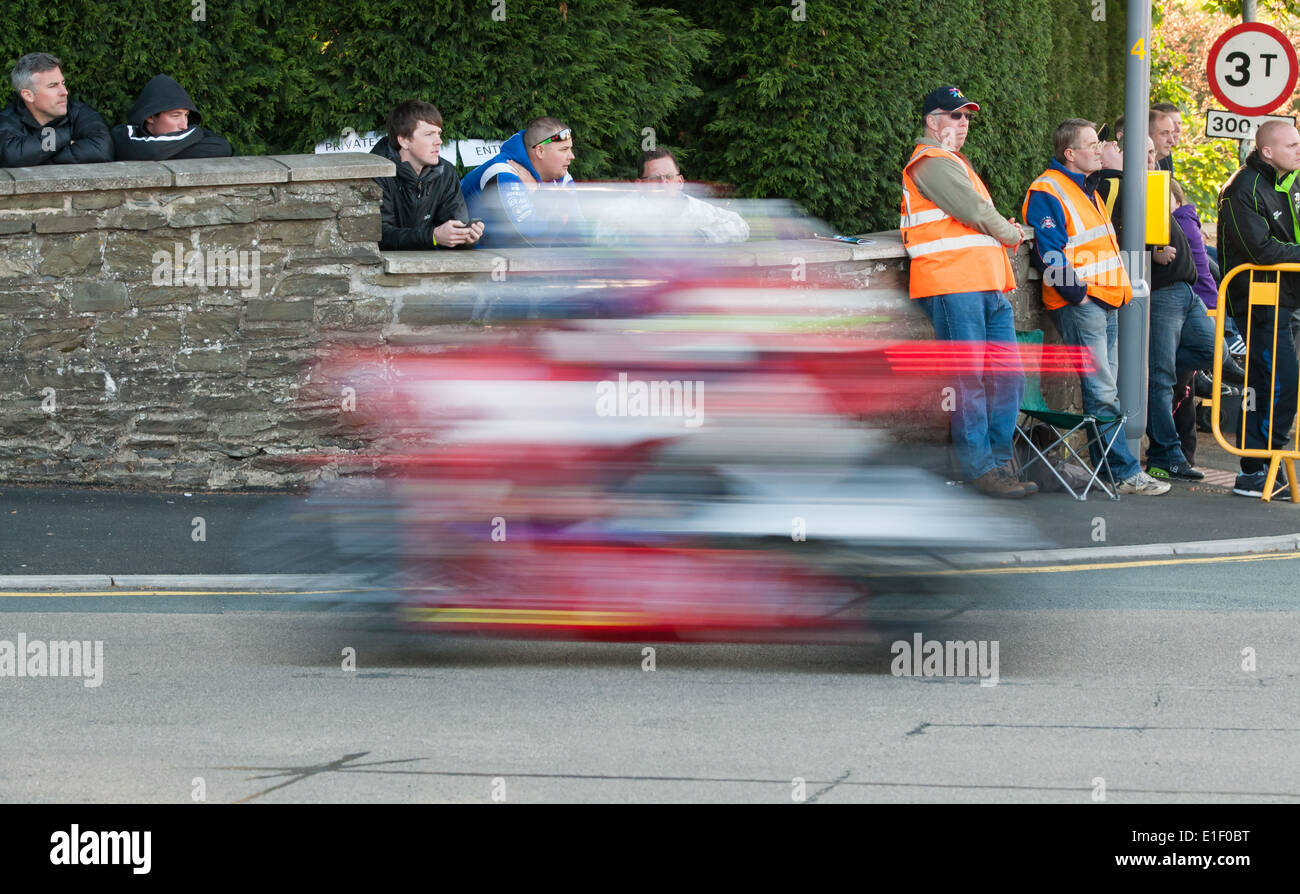 Spettatori guardare come un concorrente di velocità del passato al iconico Bray hill section dell'Isola di Man TT corso di montagna, 31/05/14. Foto Stock