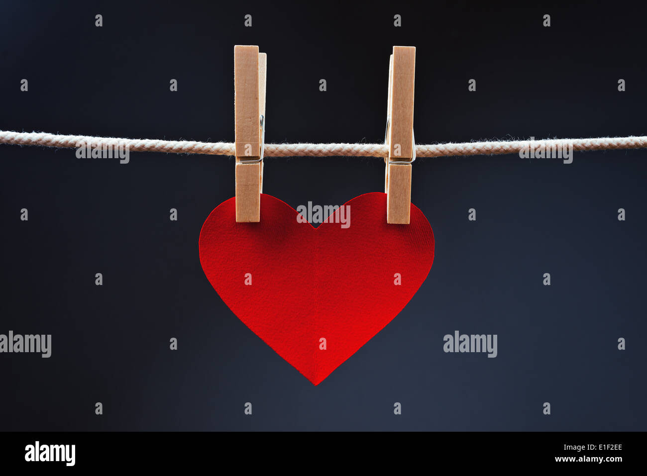 A forma di cuore il giorno di San Valentino card con spazio copia attaccato ad una corda con perni di vestiti. Il romanticismo, di amore e di affetto del concetto. Foto Stock