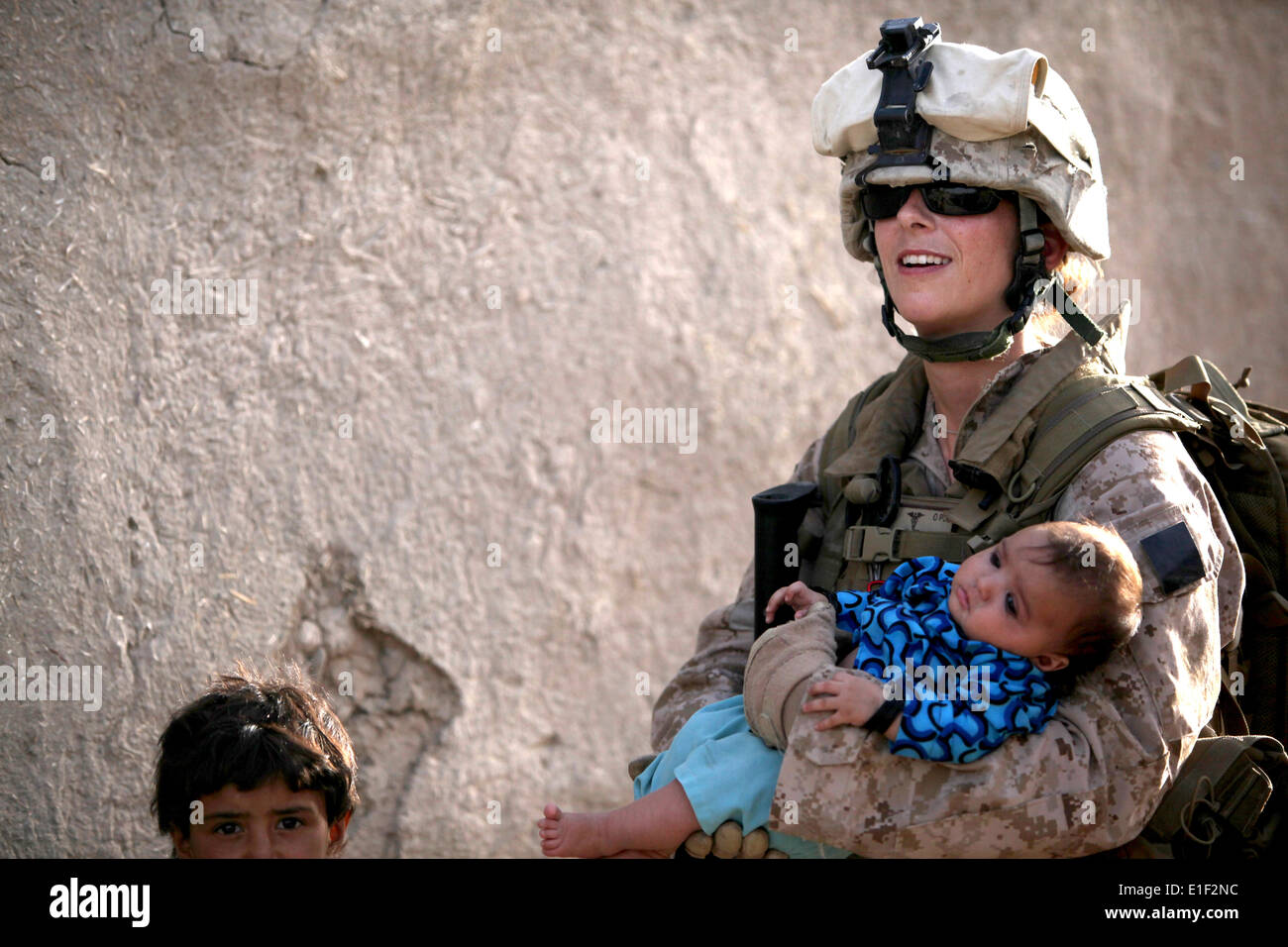 Stati Uniti Navy Petty Officer di 2a classe di Claire Ballante detiene un bambino afghano durante una pattuglia di Marines dal 1° Battaglione, 2 Ma Foto Stock