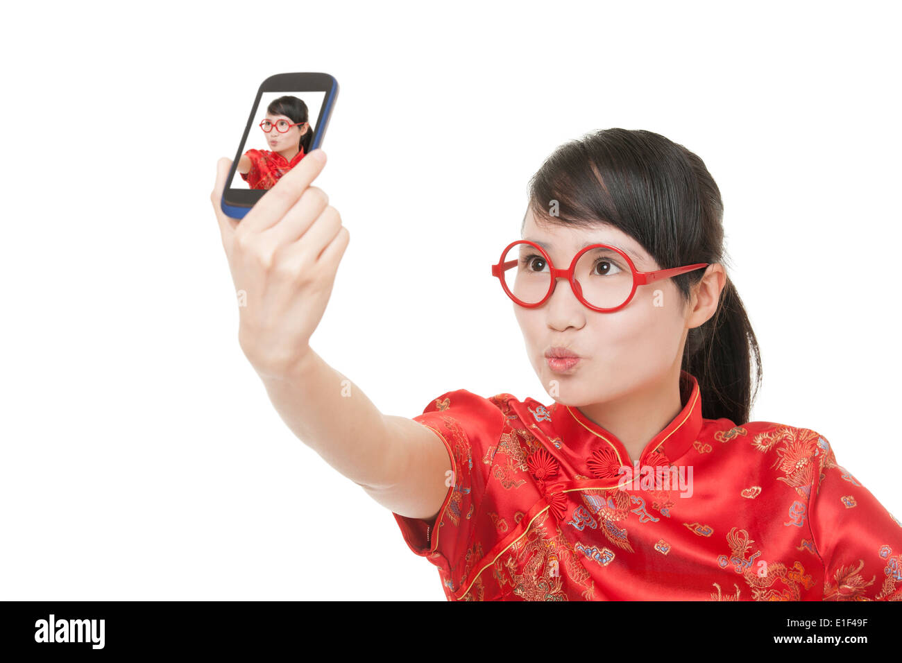 Bella donna cinese che indossa un abito tradizionale noto come un Chipao prendendo un selfie di se stessa Foto Stock