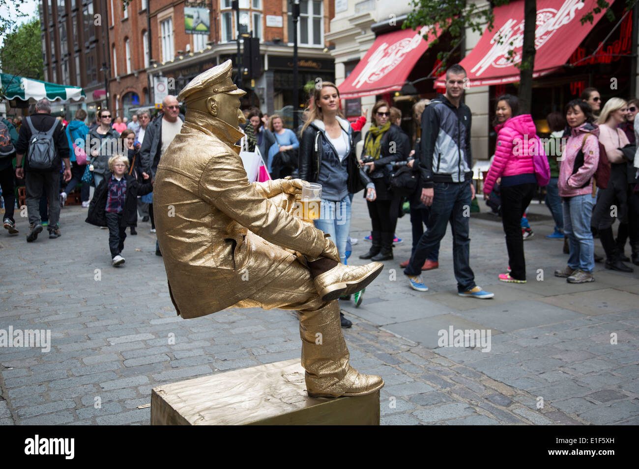 Street performer come un materiale metallico bilanciamento del dipinto "statua vivente' in Covent Garden dilettare i raccolti di folla. Londra, Regno Unito. Foto Stock
