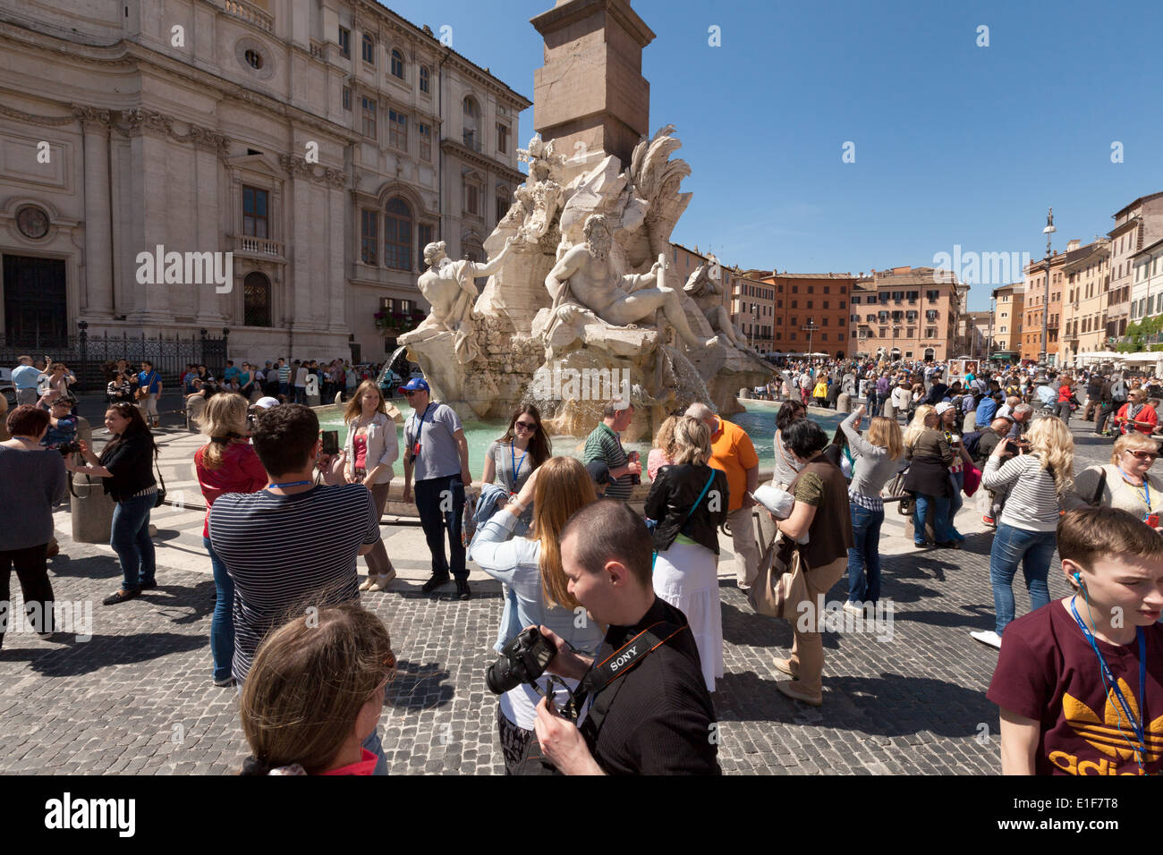 La folla di persone in Piazza Navona dai Quattro Fiumi della fontana su una soleggiata giornata di primavera, Roma Italia Europa Foto Stock