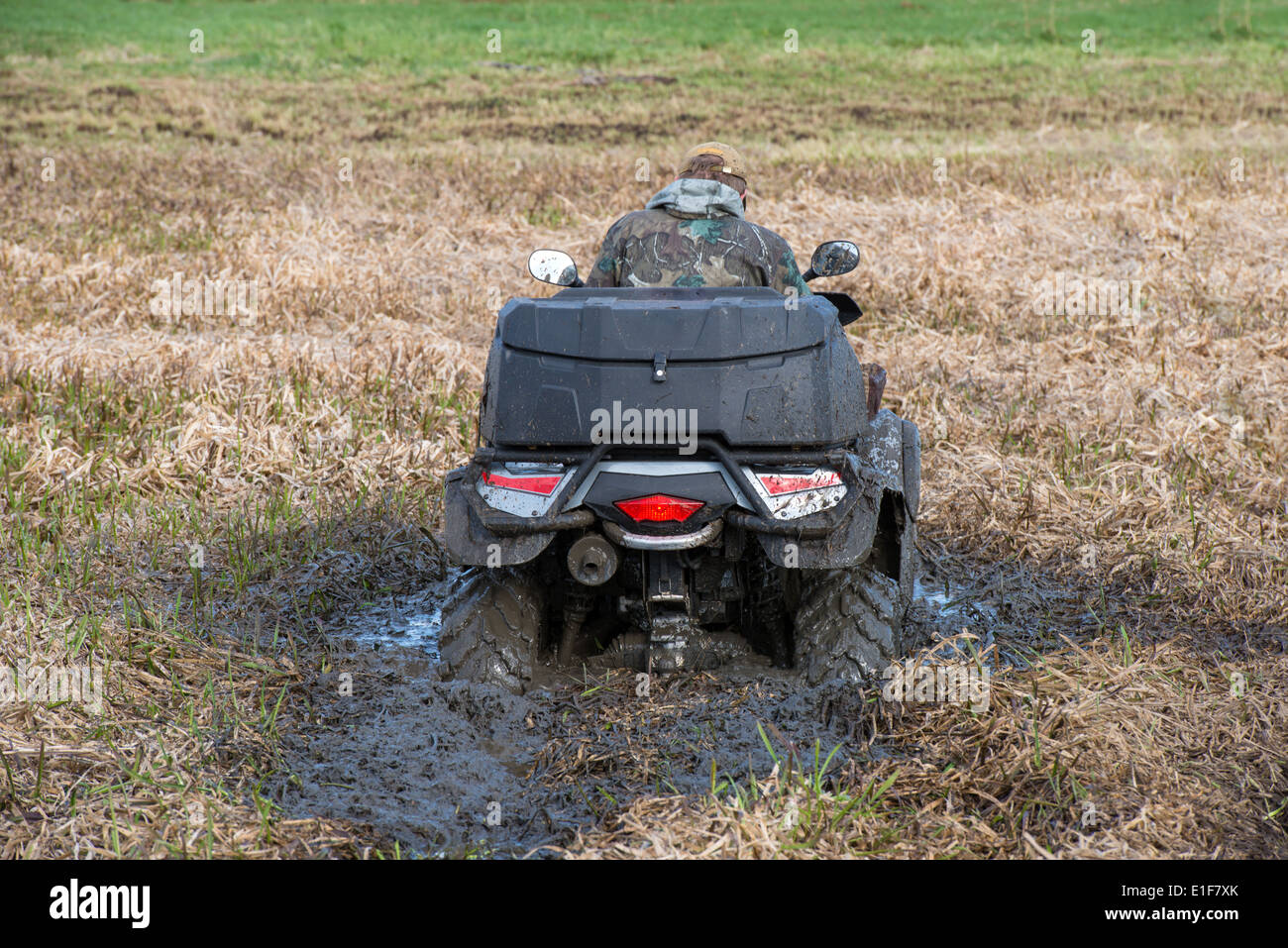 Giovane uomo mal bloccato nel fango con la sua quadbike Foto Stock