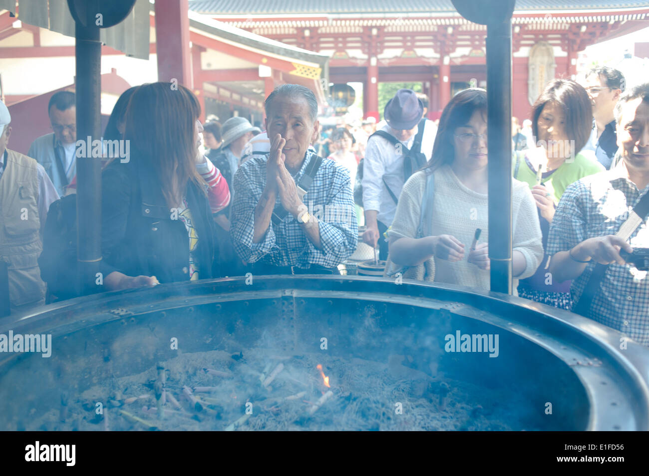 Tokyo, Giappone - 2014 - Japaneese persone si diffonde il fumo dal bruciatore di incenso o joukoro Foto Stock