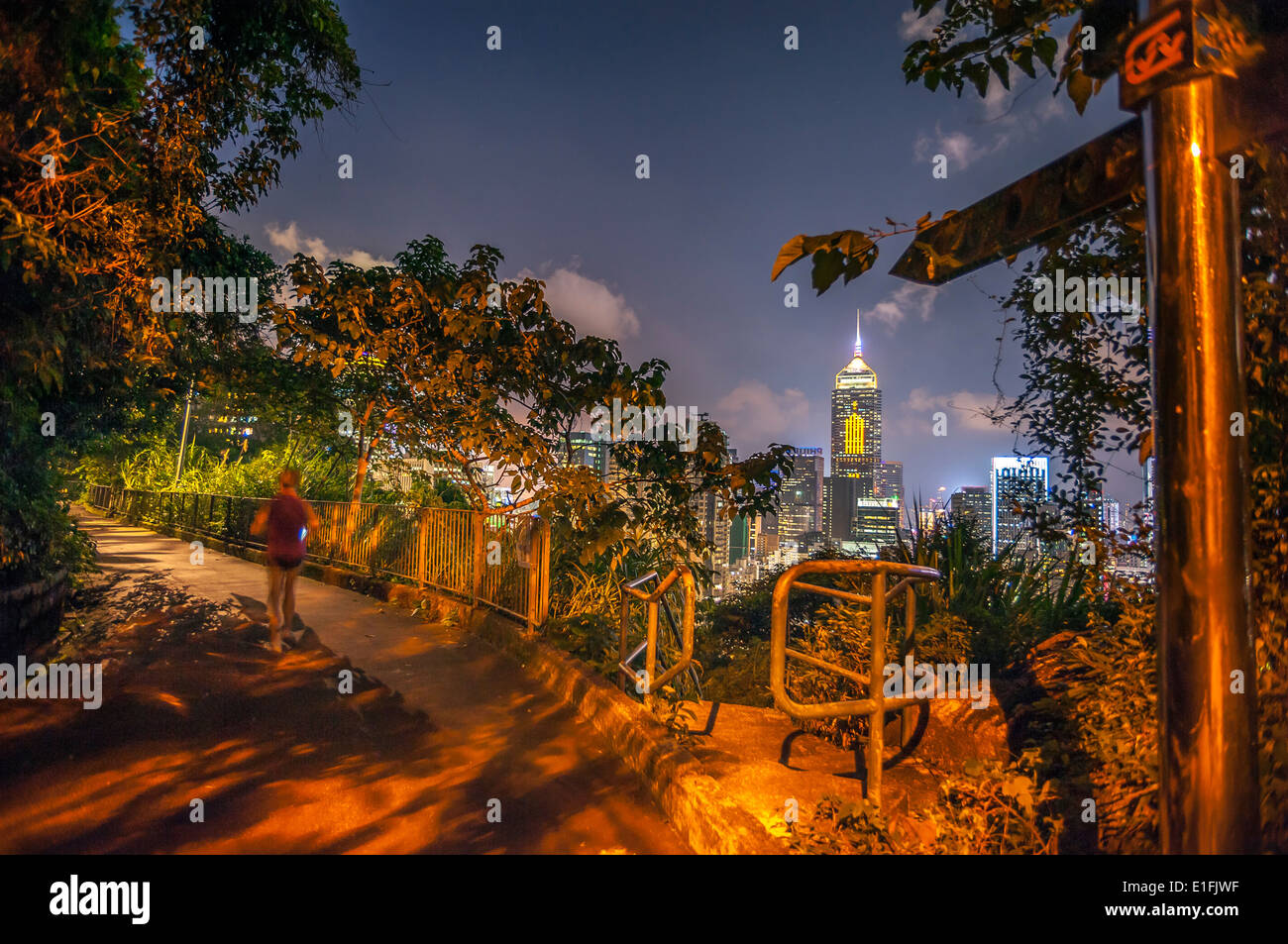 Una donna corre lungo la strada di Bowen percorso fitness di notte, Wan Chai, Hong Kong Foto Stock