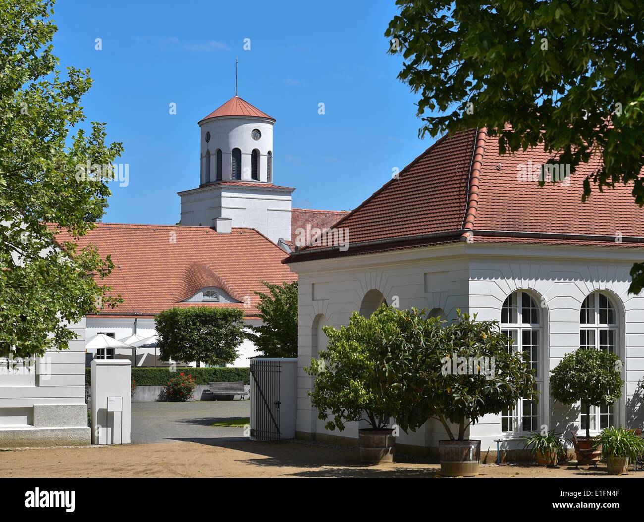 Vista l'orangerie a Neuhardenberg Palace e la torre della chiesa di Schinkel nel Neuherdenberg, 30 maggio 2014. Nel 1997, il maniero fu acquisito dal Deutscher Sparkassen- und Giroverband casse di risparmio di associazione e restaurato per 60 milioni di euro. Il re prussiano Federico Guglielmo III aveva dato la proprietà al suo stato Il cancelliere Il Principe Karl August von Hardenberg per il suo contributo alla riforma della stato di Prussia nel 1814. Foto: Patrick Pleul/dpa Foto Stock