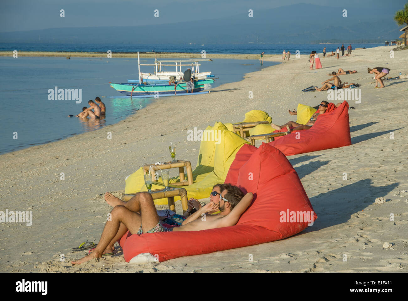 Nusa Lembongan rilassarsi su un pouf rosso sulla spiaggia Indonesia Foto Stock