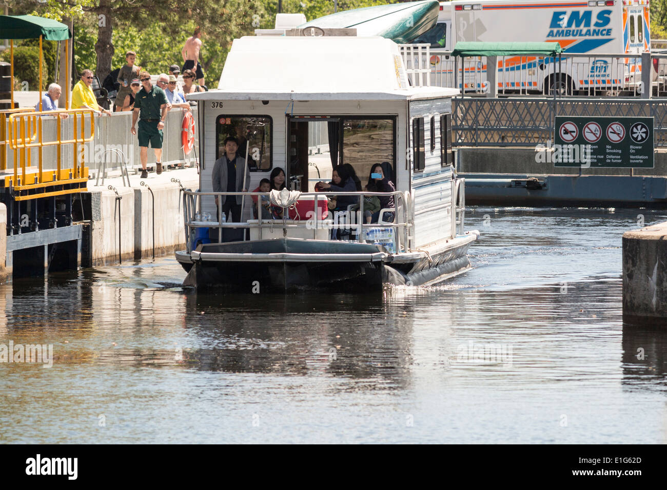 Famiglia giapponese su una casa galleggiante noleggiato dopo proveniente attraverso la serratura 34 in Fenelon Falls Ontario sulla Trent Severn Waterway. Foto Stock