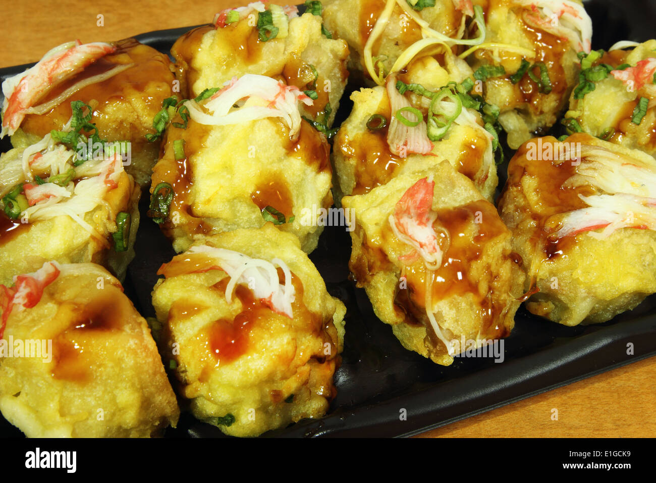 Gnocchi di giapponese nella piastra nera sulla tavola di legno Foto Stock