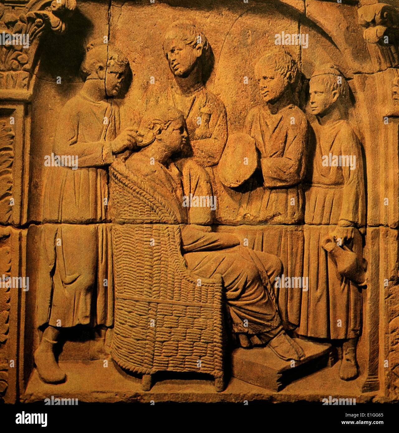 Stone scena raffigura una signora ricca seduti in un round-backed sedia in vimini con i suoi piedi appoggiati su uno sgabello. I suoi quattro schiavo-ragazze sono occupate intorno a lei: uno detiene un pallone di profumo, una seconda pone uno specchio, un terzo attende con una piccola brocca e organizzando i suoi capelli è la ornatrix - un importante membro della slave casa in attesa che ha visto anche il rouge, lip-stick e eye-ombra. In data 1° secolo A.C. Foto Stock