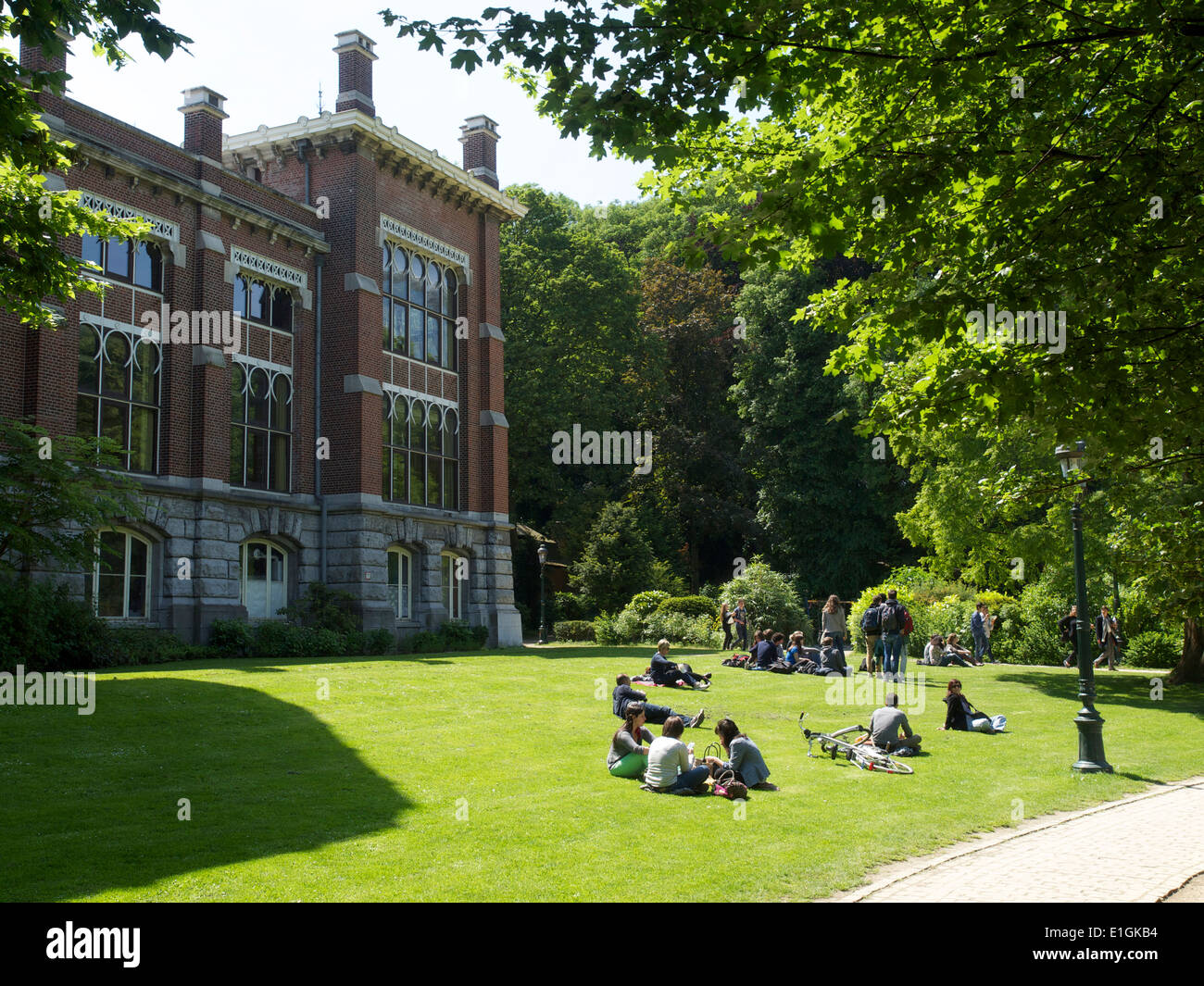 Persone rilassante su un prato nel Parco Leopold nel quartiere europeo di Bruxelles, Belgio Foto Stock