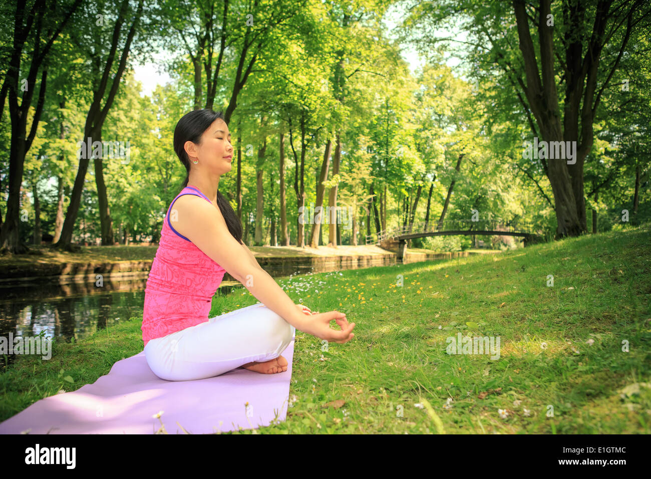 Donna fare esercizi yoga in un parco antico Foto Stock