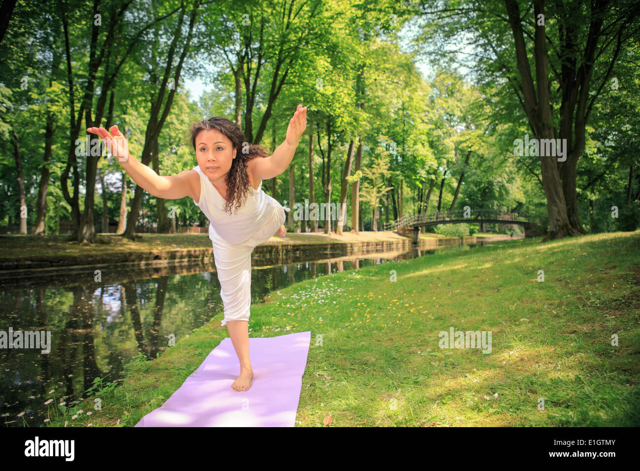 Donna fare esercizi yoga in un parco antico Foto Stock