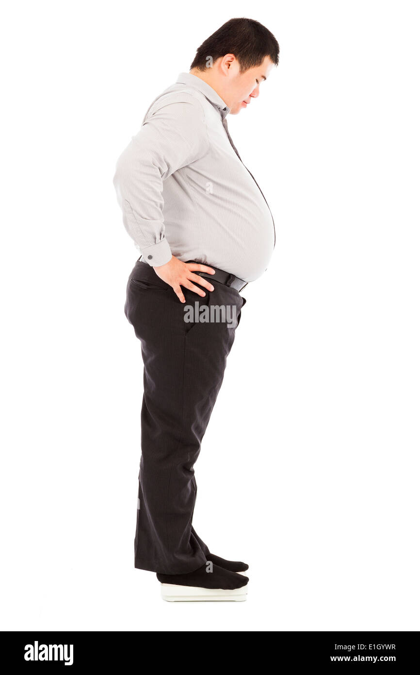 Fat business man standing sulla bilancia Foto Stock