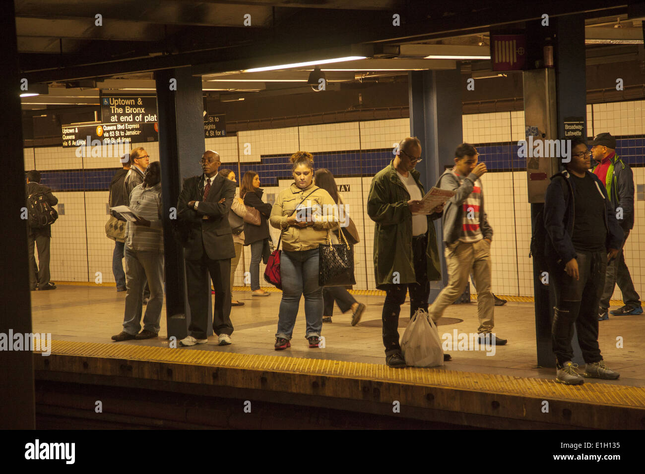 Pendolari in attesa del treno F a Broadway/Lafayette fermata a Soho, New York. Foto Stock