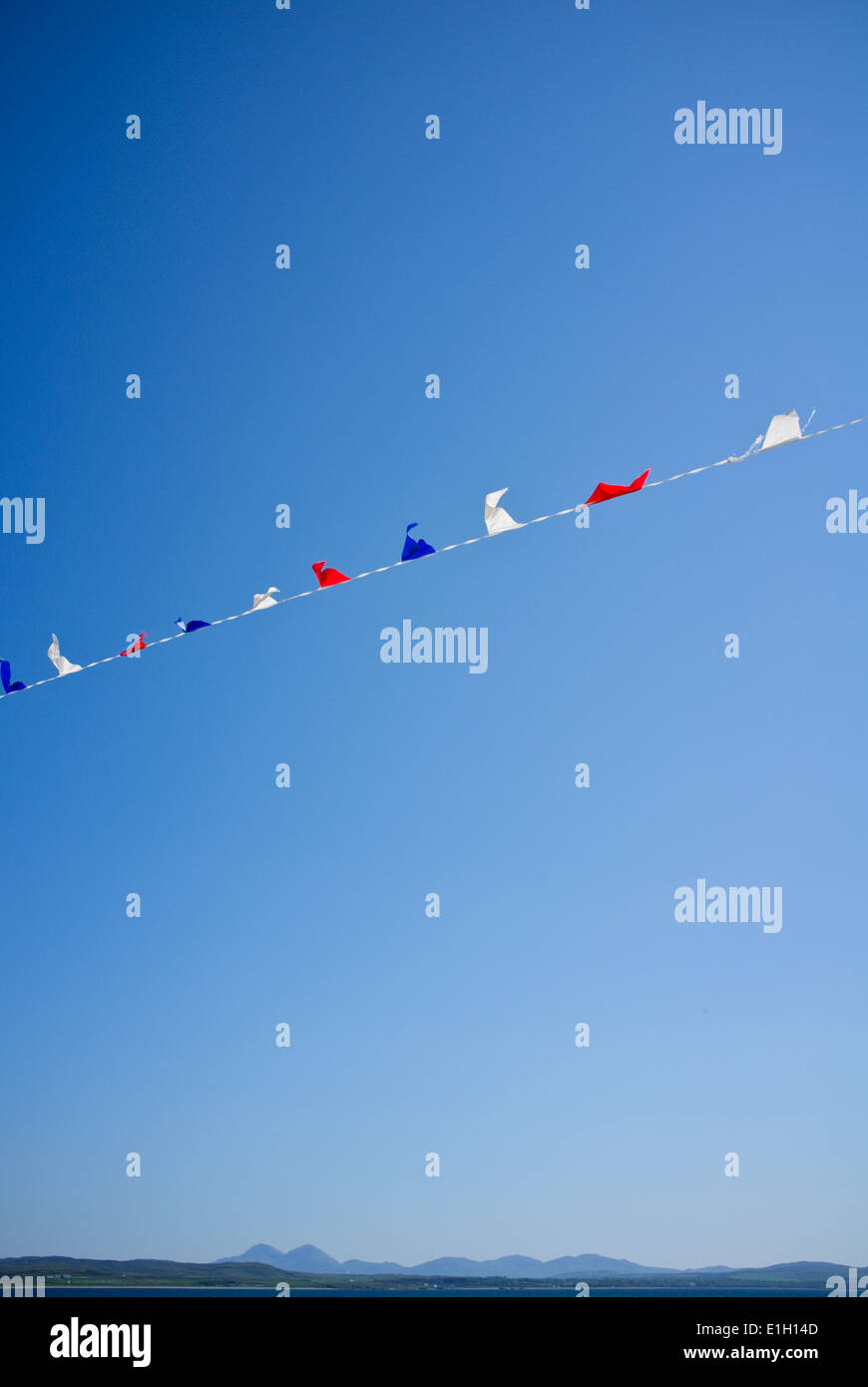 Bunting volare alto nel cielo limpido, isole delle Ebridi in lontananza Foto Stock