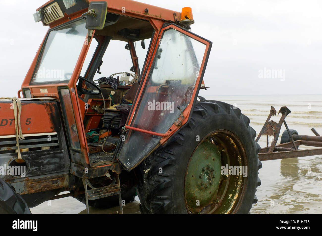 Vecchio Pescatore arrugginito il trattore e il rimorchio sulla spiaggia, bassa marea,St Aubin-sur-mer, Normandia, Francia Foto Stock
