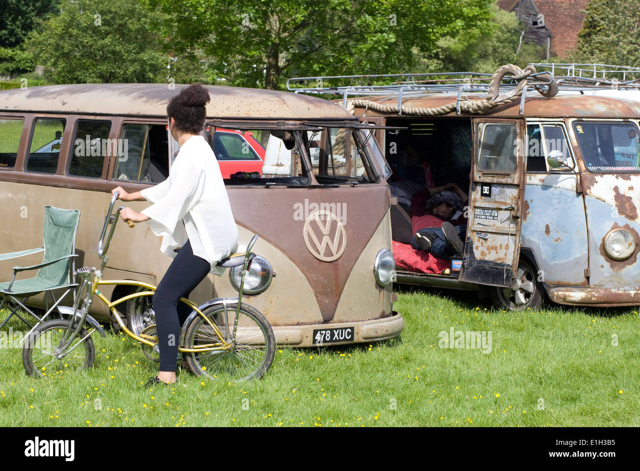 Rat Volkswagen Camper con la ragazza di un pilota bassa in bicicletta e un uomo dorme in van Foto Stock