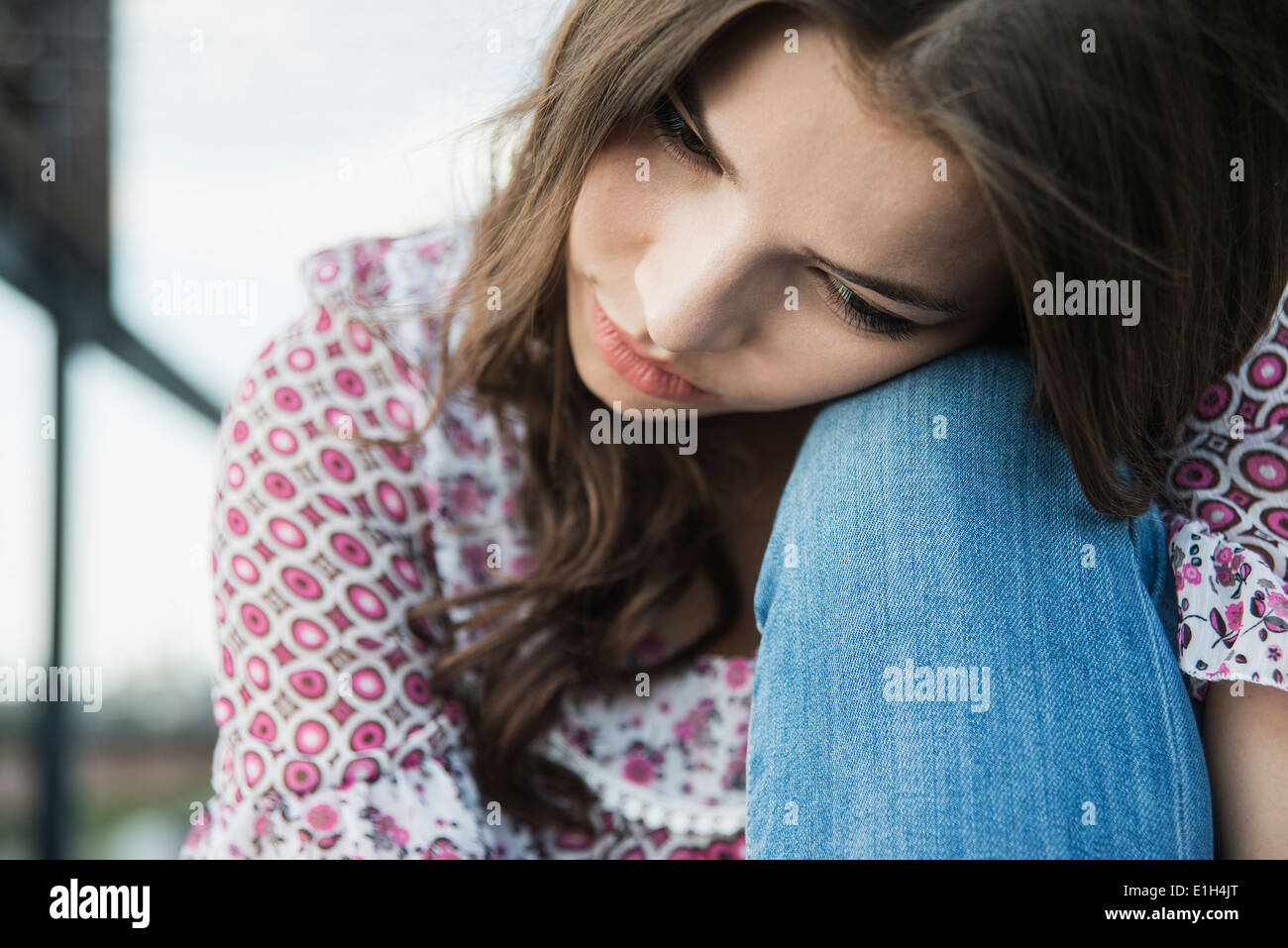 Giovane donna testa pendente sul ginocchio Foto Stock