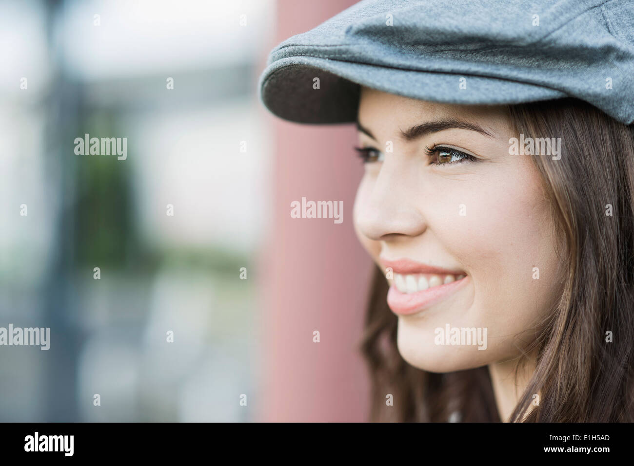 Giovane donna che indossa il tappo piatto, close up Foto Stock