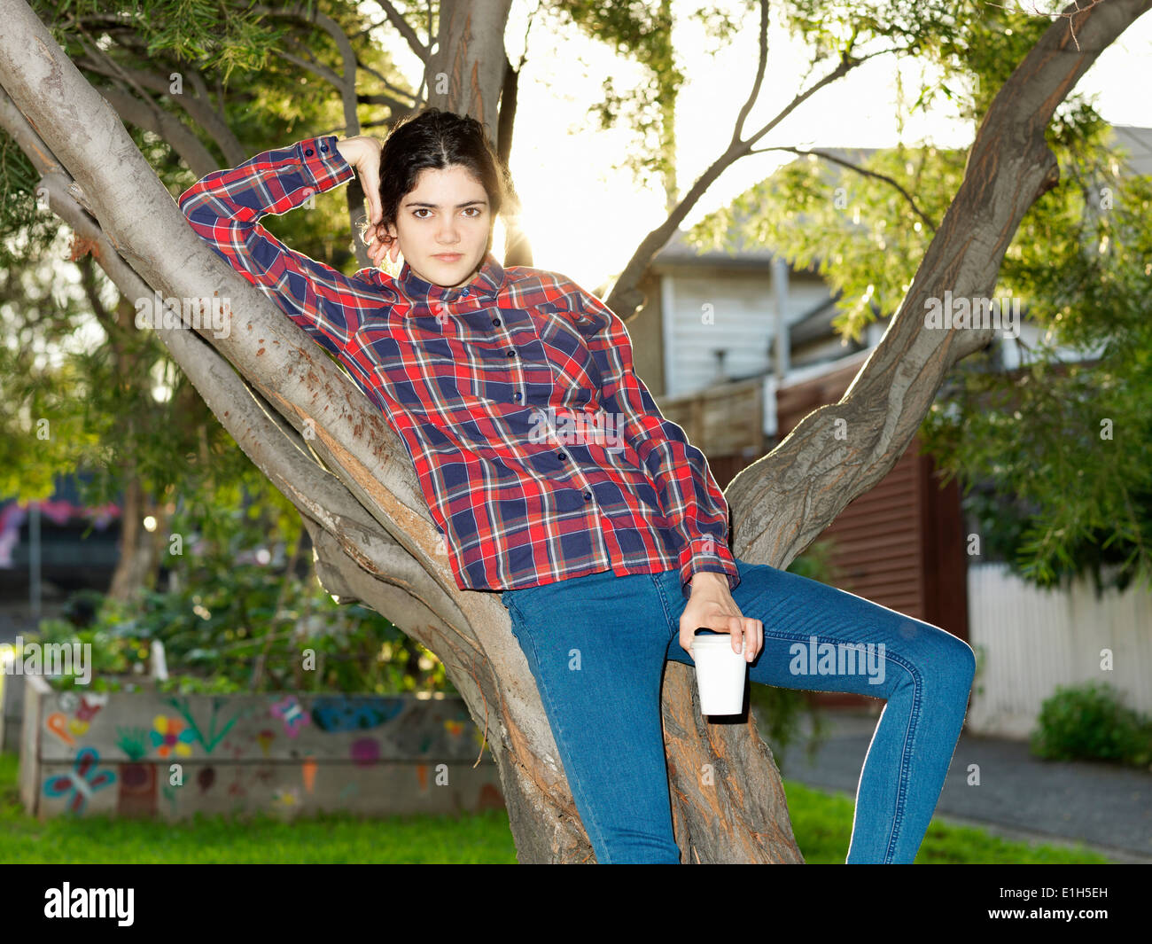Ritratto di fiducioso giovane donna contro reclinabili tree Foto Stock