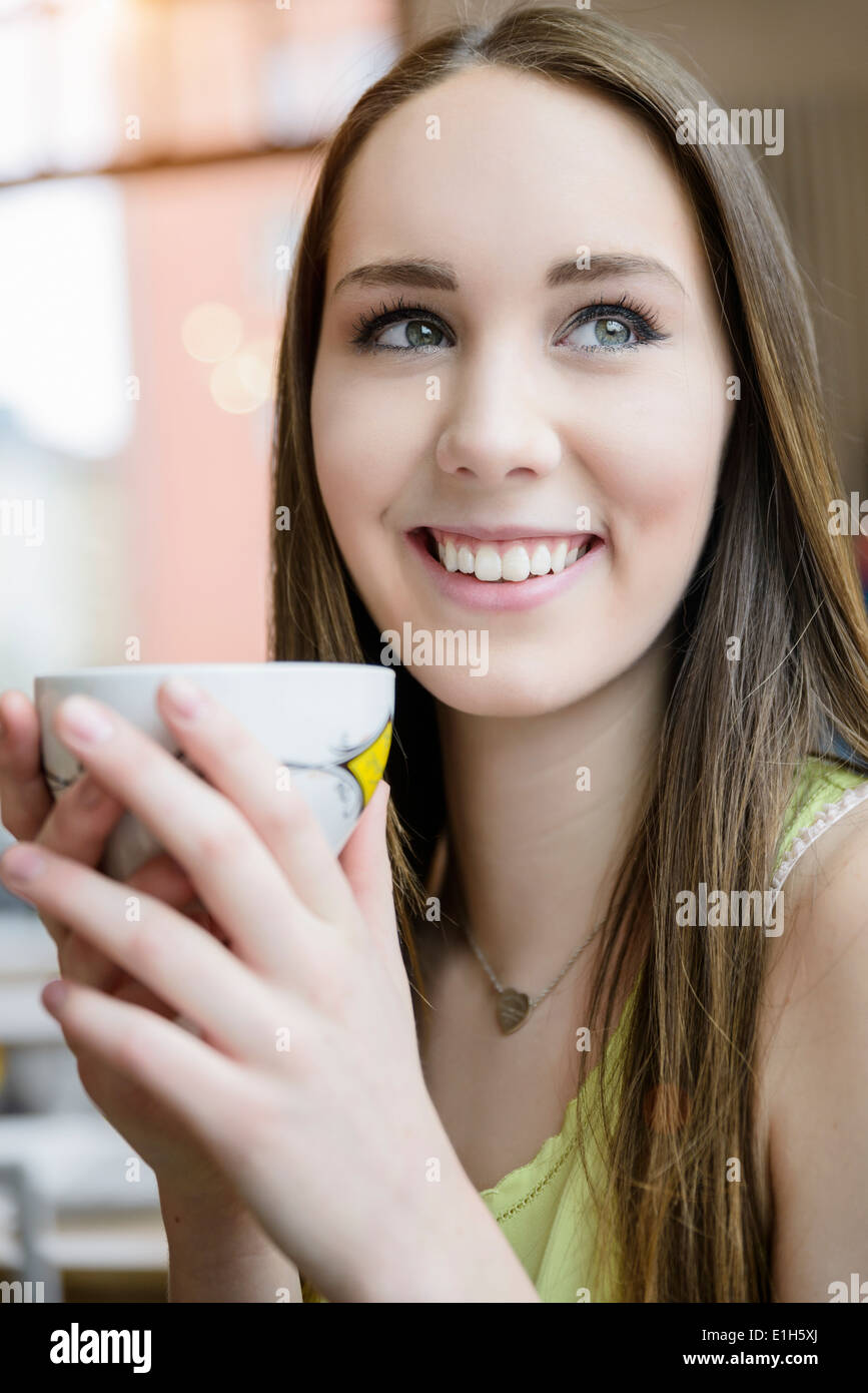 Close up ritratto di giovane donna di bere il caffè nella caffetteria Foto Stock